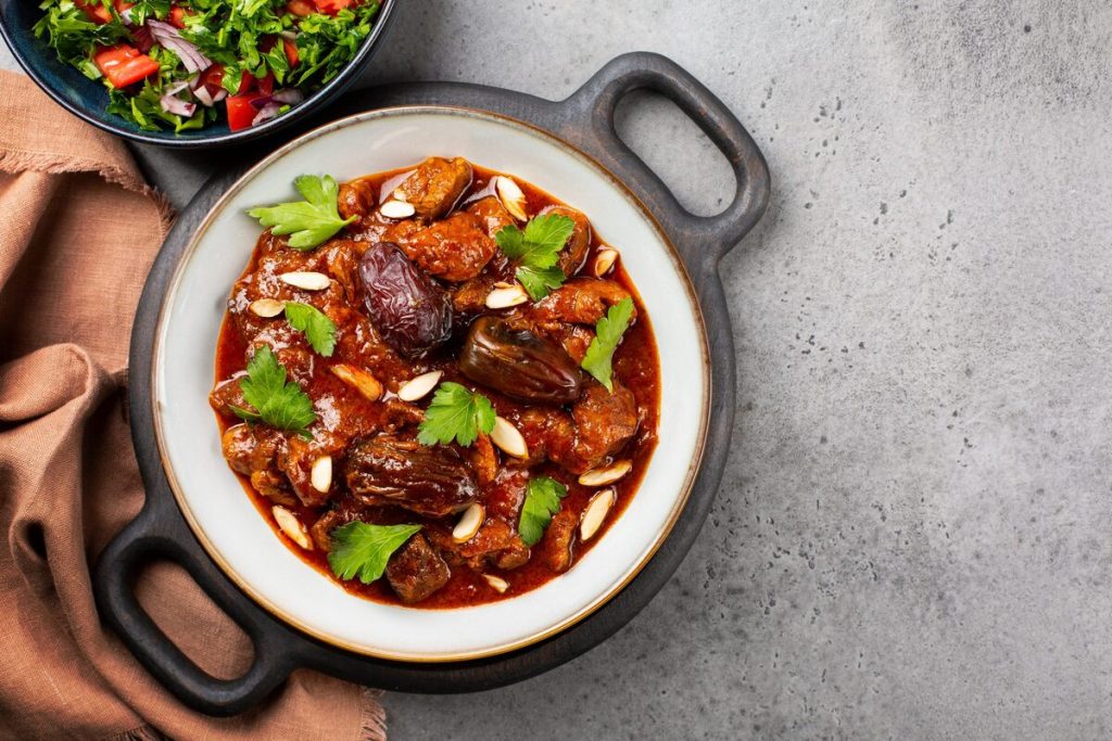 Recette de tajine d'agneau aux épices, amandes et dattes au four